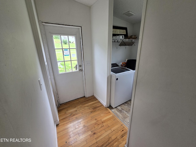 washroom featuring laundry area, light wood-style flooring, separate washer and dryer, and visible vents