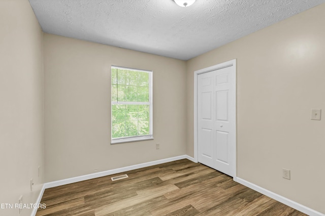 330 Ridgeview Dr, Oliver Springs, TN 37840 - unfurnished bedroom featuring a textured ceiling, baseboards, a closet, and wood finished floors