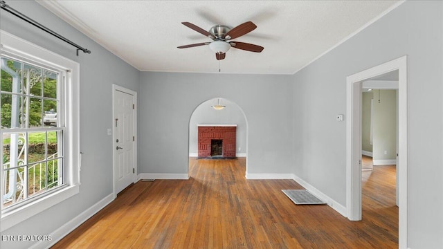 953 Maynard Ave, Knoxville, TN 37917 - empty room with a brick fireplace, plenty of natural light, wood finished floors, baseboards, and ornamental molding