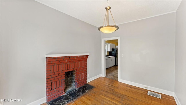 953 Maynard Ave, Knoxville, TN 37917 - unfurnished living room featuring wood finished floors, baseboards, and a brick fireplace