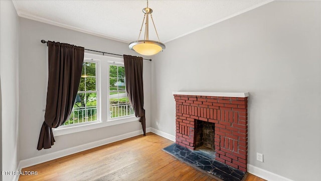 953 Maynard Ave, Knoxville, TN 37917 - unfurnished living room with wood finished floors, baseboards, a brick fireplace, and ornamental molding