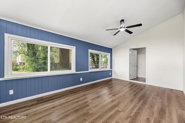 unfurnished bedroom with a ceiling fan, crown molding, wood finished floors, baseboards, and lofted ceiling