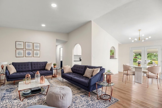 living area featuring arched walkways, lofted ceiling, an inviting chandelier, recessed lighting, and light wood-style flooring