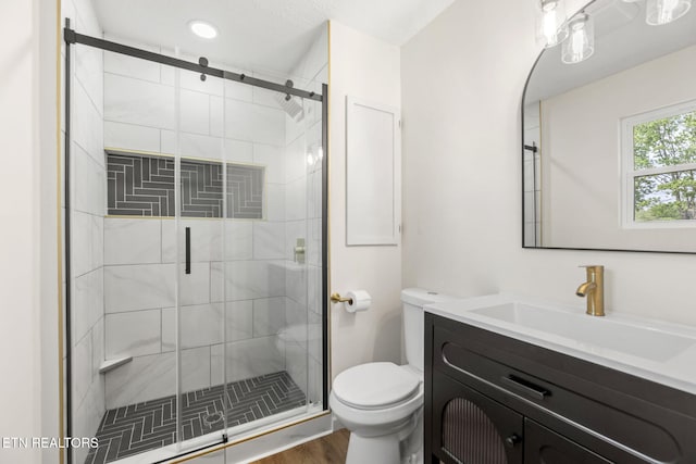 full bath with toilet, a shower stall, wood finished floors, and vanity