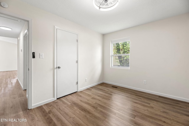 unfurnished bedroom featuring baseboards and wood finished floors