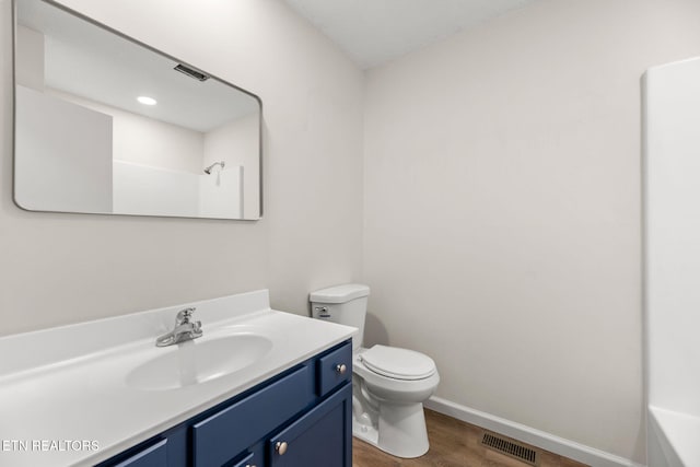 full bathroom with vanity, toilet, baseboards, wood finished floors, and visible vents