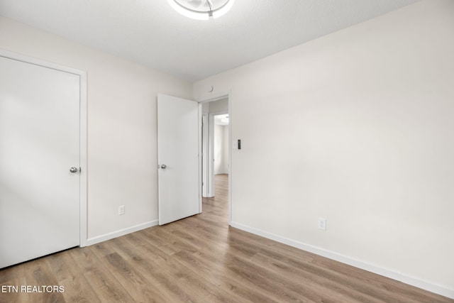 unfurnished bedroom with baseboards and wood finished floors