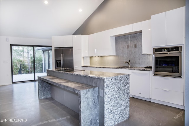 194 Forest View Dr, Crossville, TN 38558 - kitchen with high vaulted ceiling, a center island, tasteful backsplash, a sink, and appliances with stainless steel finishes