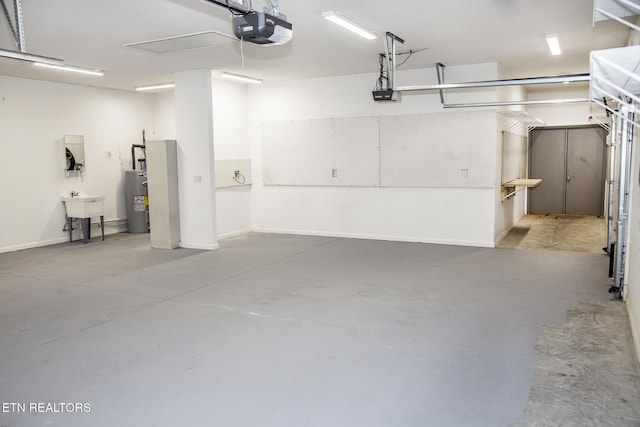 194 Forest View Dr, Crossville, TN 38558 - garage featuring baseboards, a garage door opener, a sink, and water heater