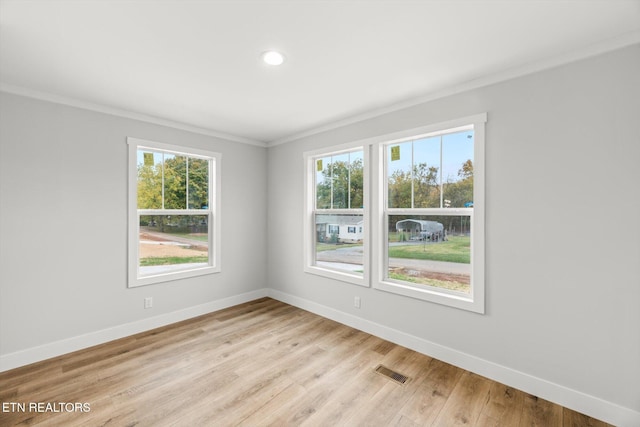 unfurnished room with baseboards, visible vents, ornamental molding, and a healthy amount of sunlight