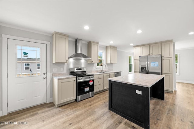kitchen with crown molding, a sink, light countertops, stainless steel appliances, and wall chimney exhaust hood
