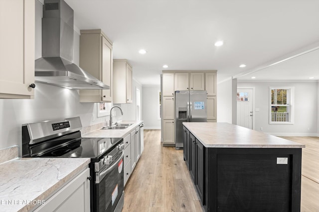 kitchen with light wood-style floors, wall chimney range hood, recessed lighting, a sink, and stainless steel appliances