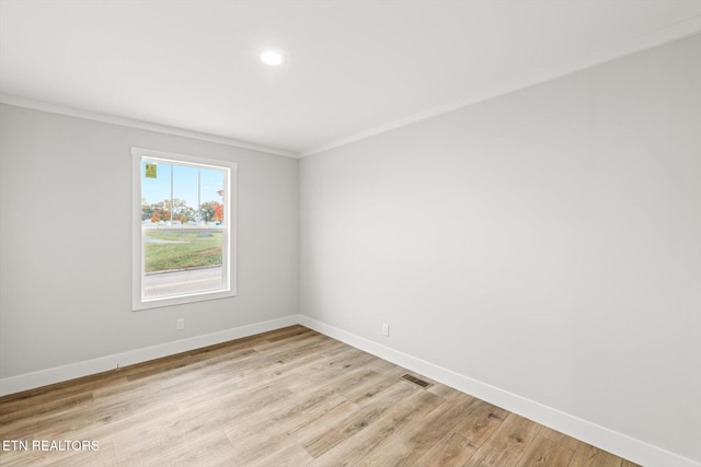 spare room with visible vents, light wood-type flooring, baseboards, ornamental molding, and recessed lighting