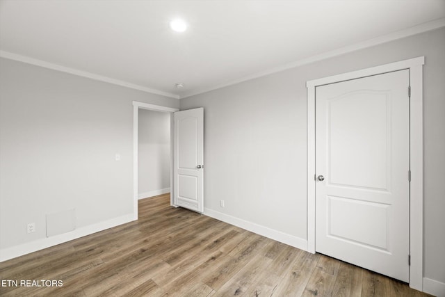 unfurnished bedroom featuring crown molding, baseboards, recessed lighting, and wood finished floors