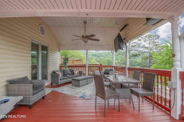 deck with an outdoor living space, ceiling fan, and outdoor dining space