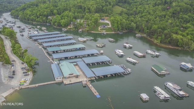 birds eye view of property featuring a water view and a wooded view