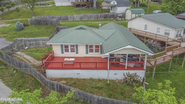 back of house featuring a storage shed, crawl space, metal roof, and a fenced backyard