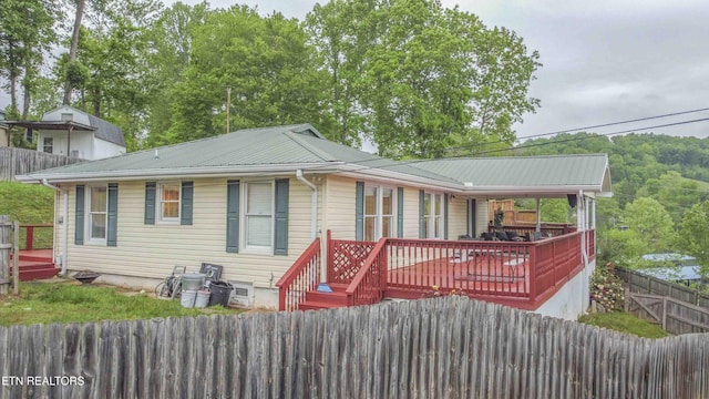 rear view of house with fence private yard and metal roof