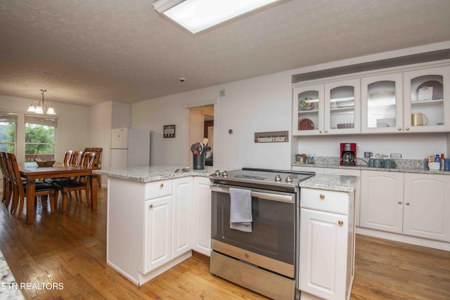kitchen featuring white cabinets, electric range, a textured ceiling, light wood-style flooring, and freestanding refrigerator