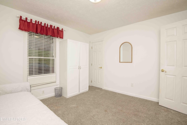 unfurnished bedroom with baseboards, carpet, and a textured ceiling