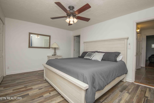 bedroom with a textured ceiling, baseboards, a ceiling fan, and wood finished floors
