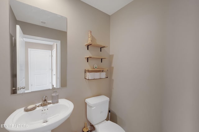 bathroom featuring visible vents, a sink, and toilet