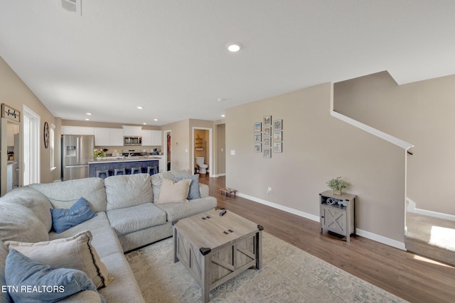 living room with baseboards, recessed lighting, wood finished floors, and visible vents
