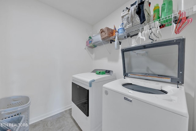 laundry area with laundry area, baseboards, and washer and dryer