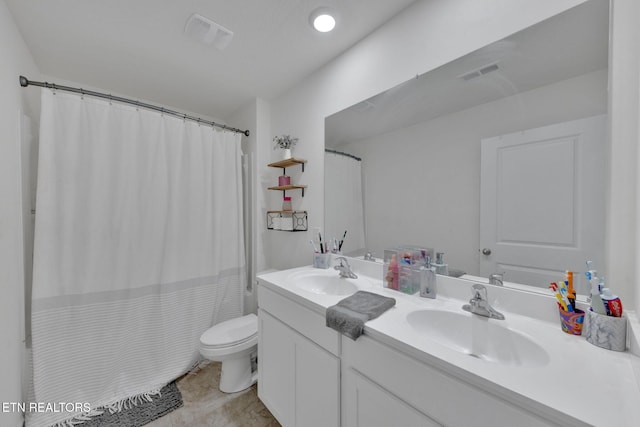 bathroom with toilet, visible vents, and a sink