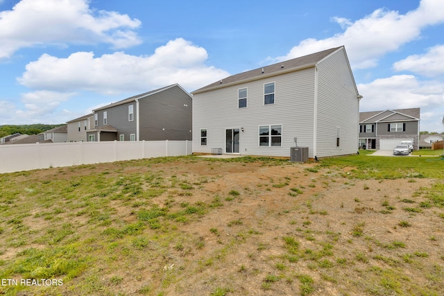 rear view of house featuring fence and central AC unit