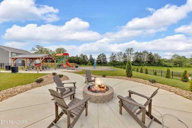 view of patio / terrace with a gazebo, a playground, an outdoor fire pit, and fence