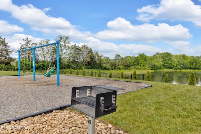 community play area featuring fence and a yard