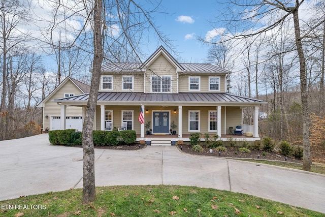 view of front of house with concrete driveway, a standing seam roof, metal roof, and a porch