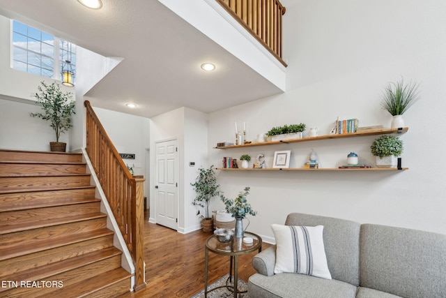 living room featuring recessed lighting, baseboards, wood finished floors, and stairway