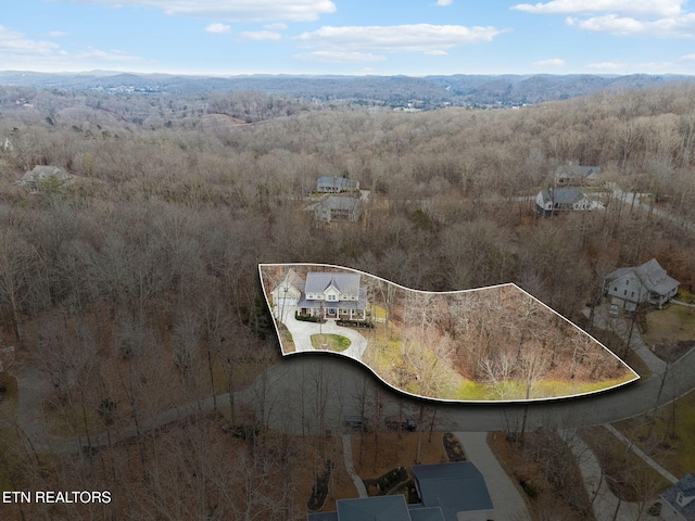 drone / aerial view with a wooded view