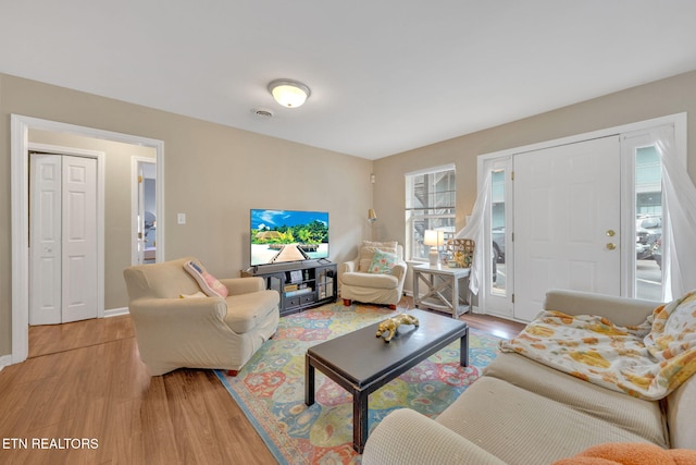 living area with baseboards and light wood-style floors