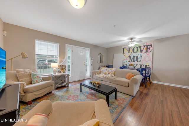 living area with baseboards, a ceiling fan, and wood finished floors