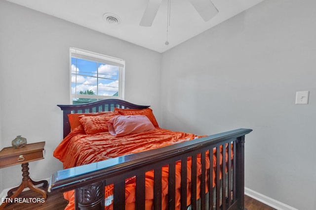 bedroom featuring ceiling fan, baseboards, visible vents, and wood finished floors