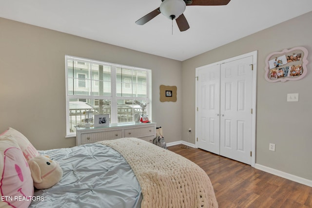 bedroom featuring dark wood-type flooring, a ceiling fan, baseboards, and a closet