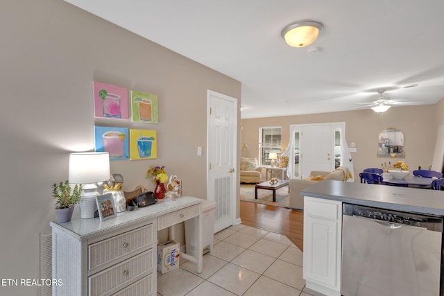 kitchen featuring a ceiling fan, open floor plan, white cabinetry, light tile patterned floors, and stainless steel dishwasher