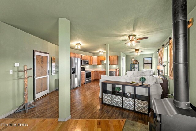 kitchen with ceiling fan, light countertops, stainless steel appliances, baseboards, and wood finished floors