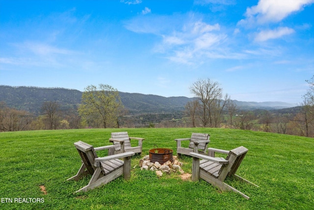 view of yard with an outdoor fire pit and a mountain view