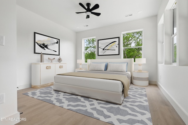 bedroom featuring visible vents, baseboards, ceiling fan, and wood finished floors