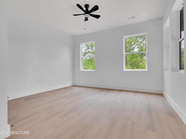 spare room featuring a ceiling fan, baseboards, visible vents, and light wood-style flooring