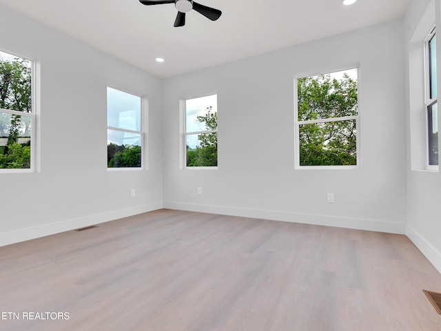 unfurnished room featuring ceiling fan, visible vents, plenty of natural light, and light wood-style floors