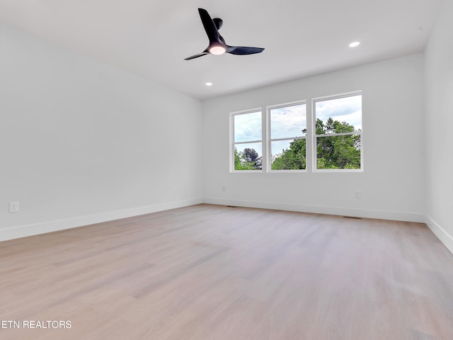empty room with baseboards, recessed lighting, and light wood-style flooring