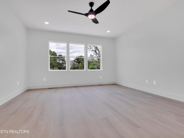 empty room featuring light wood-type flooring, a ceiling fan, baseboards, and recessed lighting