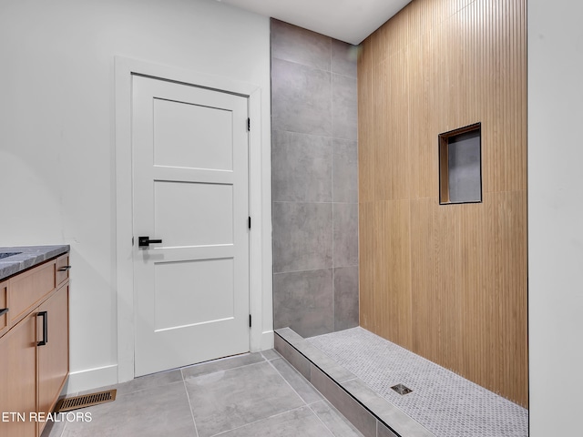 bathroom featuring vanity, tiled shower, and visible vents