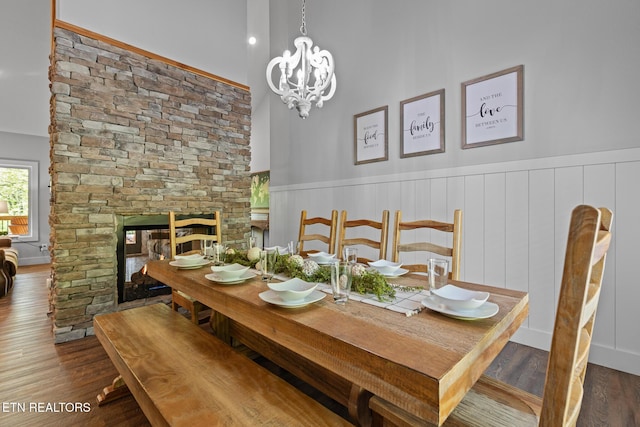 3487 Summit Trails Dr, Sevierville, TN 37862 - dining area with a wainscoted wall, a stone fireplace, wood finished floors, and a chandelier