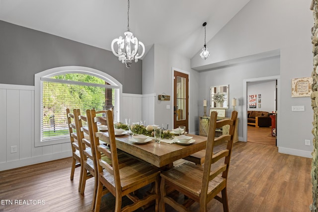 3487 Summit Trails Dr, Sevierville, TN 37862 - dining area featuring a decorative wall, high vaulted ceiling, a chandelier, a wainscoted wall, and wood finished floors